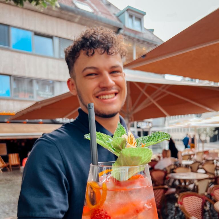 Ein lächelnder Kellner mit Aperol-Spritz