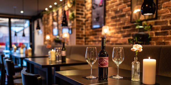 Rotwein in edlen Gläsern auf einem Tisch im Innenraum des Restaurants